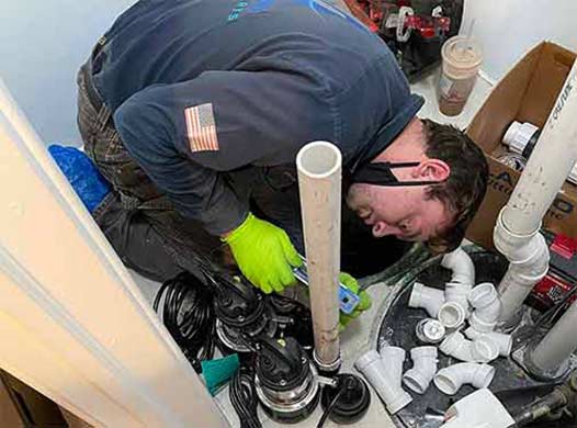 a plumber replacing a sump pump.