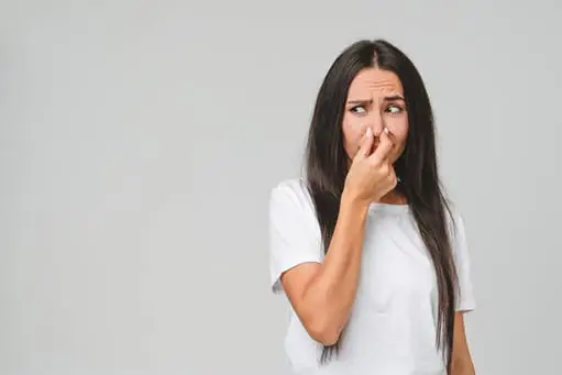 a woman smelling foul odors coming from her drain.