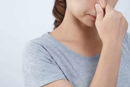 a woman smelling foul sewer odors.